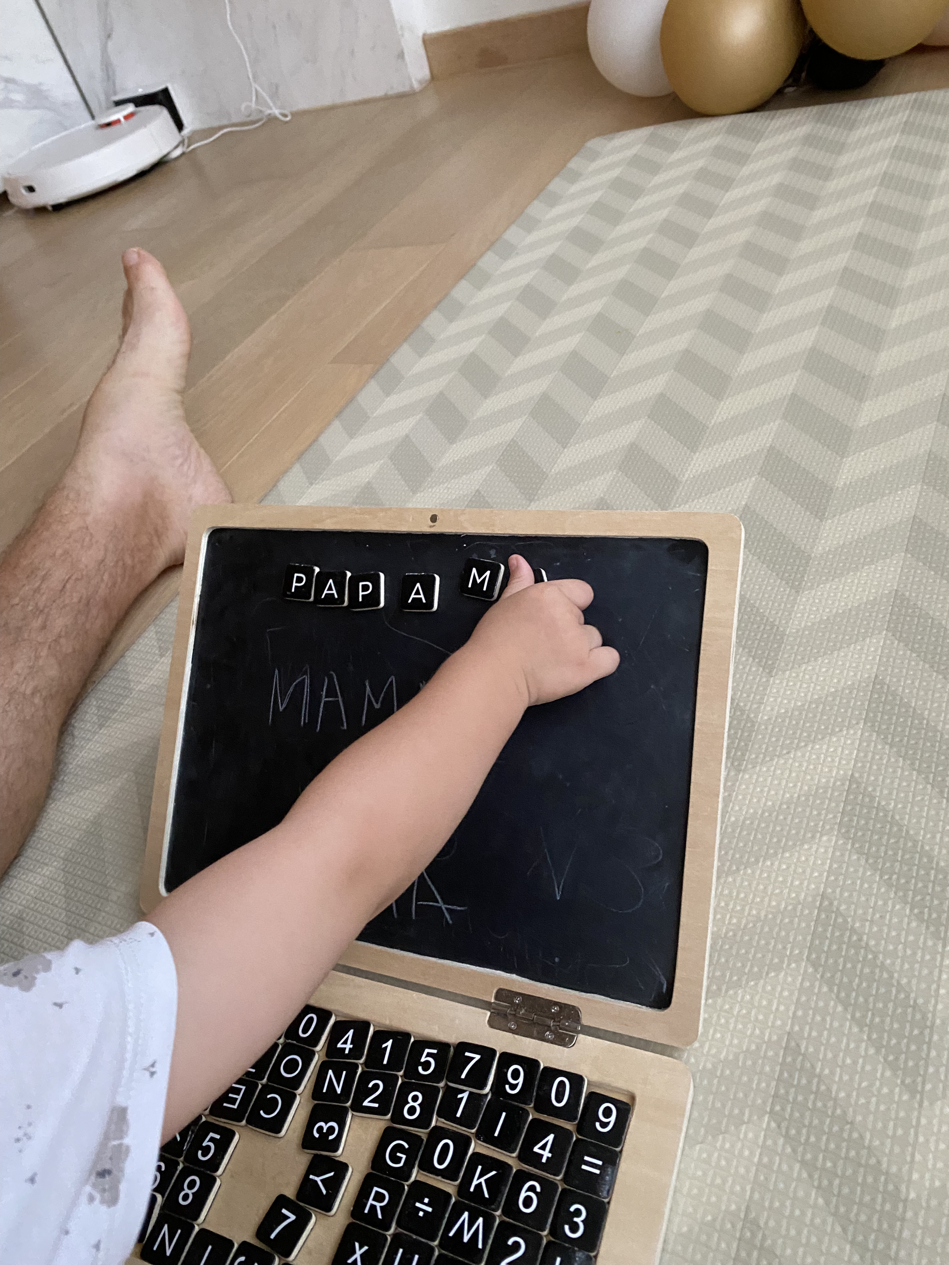 A children's blackboard resembling a laptop computer, with magnetic letters and symbols at the keyboard section