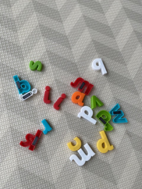 A photo of an assortment of magnetic letters, lying on the ground