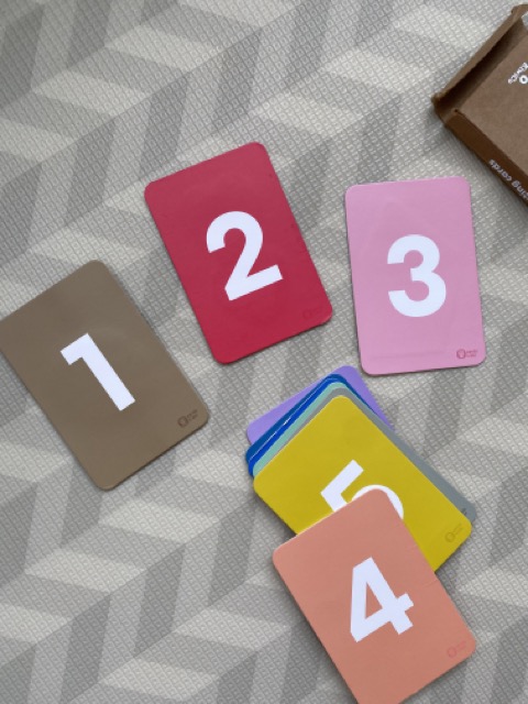 A photo of flashcards on the ground, with the cards 1 through 4 facing upwards